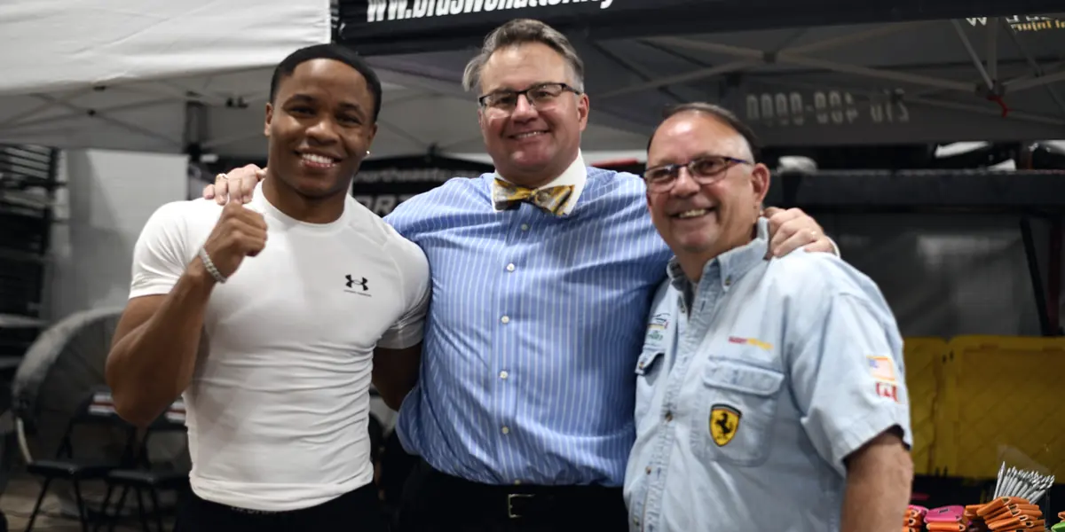 Boxer Floyd 'Kid Austin' Schofield with his arm around Mark Braswell at the Braswell Law tent
